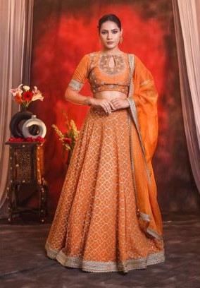 The orange rust color lehnga with abstract embroidery pattern in different size of sequin work paired with heavy embroidery blouse in dabka